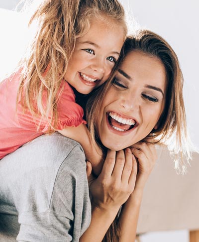 mother and young daughter laughing