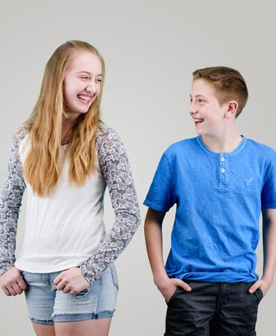 two siblings smiling at each other